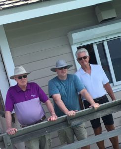 three men standing together who look like family 