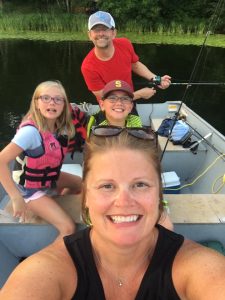 family in a boat at a minnesota family resort 