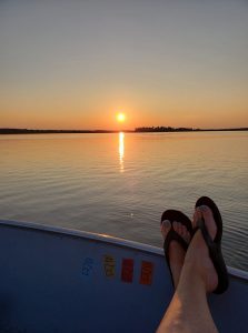 feet up on the side of a boat at sunset on a minnesota family resort vacation