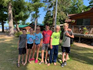 family standing in front of a cabin at a minnesota resort 