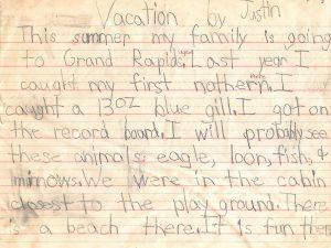 Hand printed essay titled Vacation by Justin. This summer my family is going to Grand Rapids. Last year I caught my first northern. I caught a 13 ounce blue gill. I got on the record board. I will probably see these animals: eagle, loon, fish, and minnows. We were in the cabin closest to the playground. There is a beach there. It is fun there.