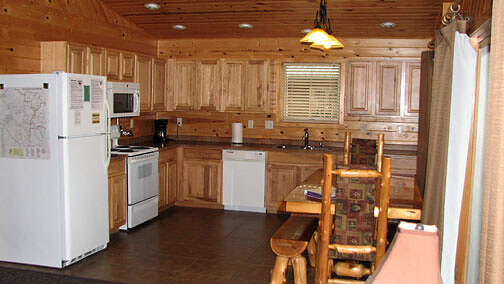 The kitchen is fully furnished with pots, pans and dishes.