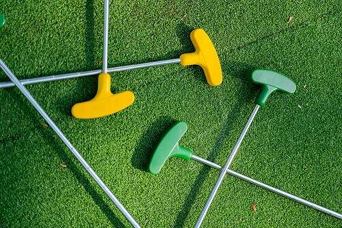 mini golf clubs on green