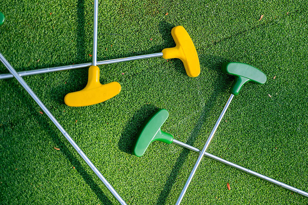 mini golf clubs on green