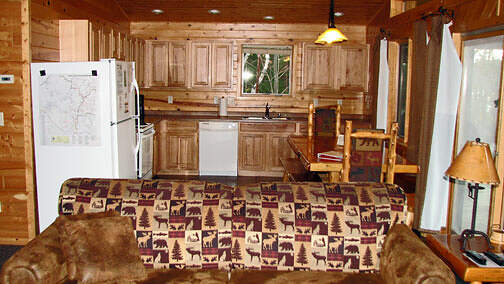 The kitchen is full furnished with pots, pans and dishes. The log table seats up to 12.